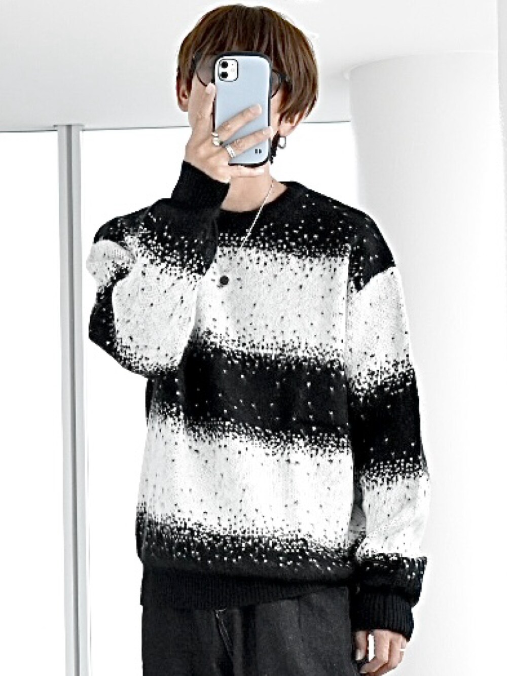 ブラック系のニット/セーター、ブラック系のダウンベスト、ブラック系のデニムパンツを着用したメンズの秋コーディネートの4枚目の写真