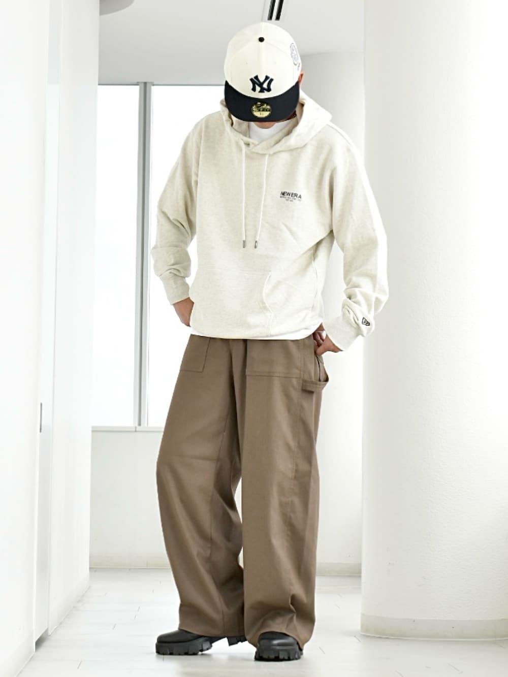 ブラック系のブーツ、ホワイト系のパーカー、ベージュ系のパンツを着用したメンズの秋コーディネートの4枚目の写真