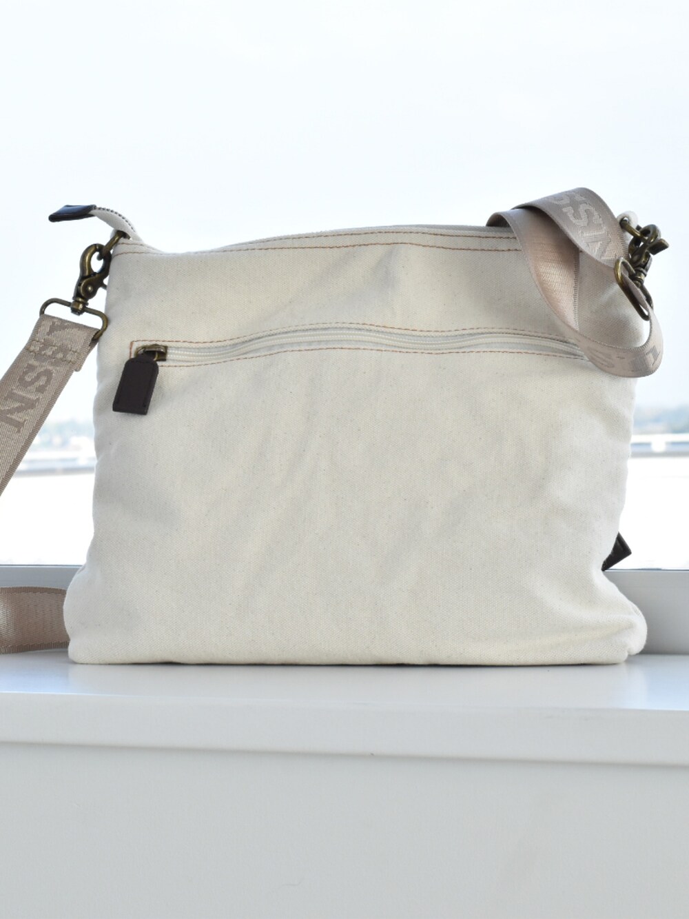 ホワイト系のショルダーバッグ、グレー系のベスト、ベージュ系のTシャツ/カットソーを着用したメンズの春コーディネートの4枚目の写真