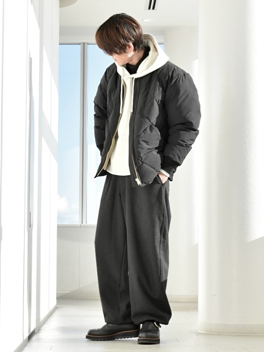 ホワイト系のパーカー、ブラック系のダウンジャケット/コート、ブラック系のトップスを着用したメンズの冬コーディネートの3枚目の写真