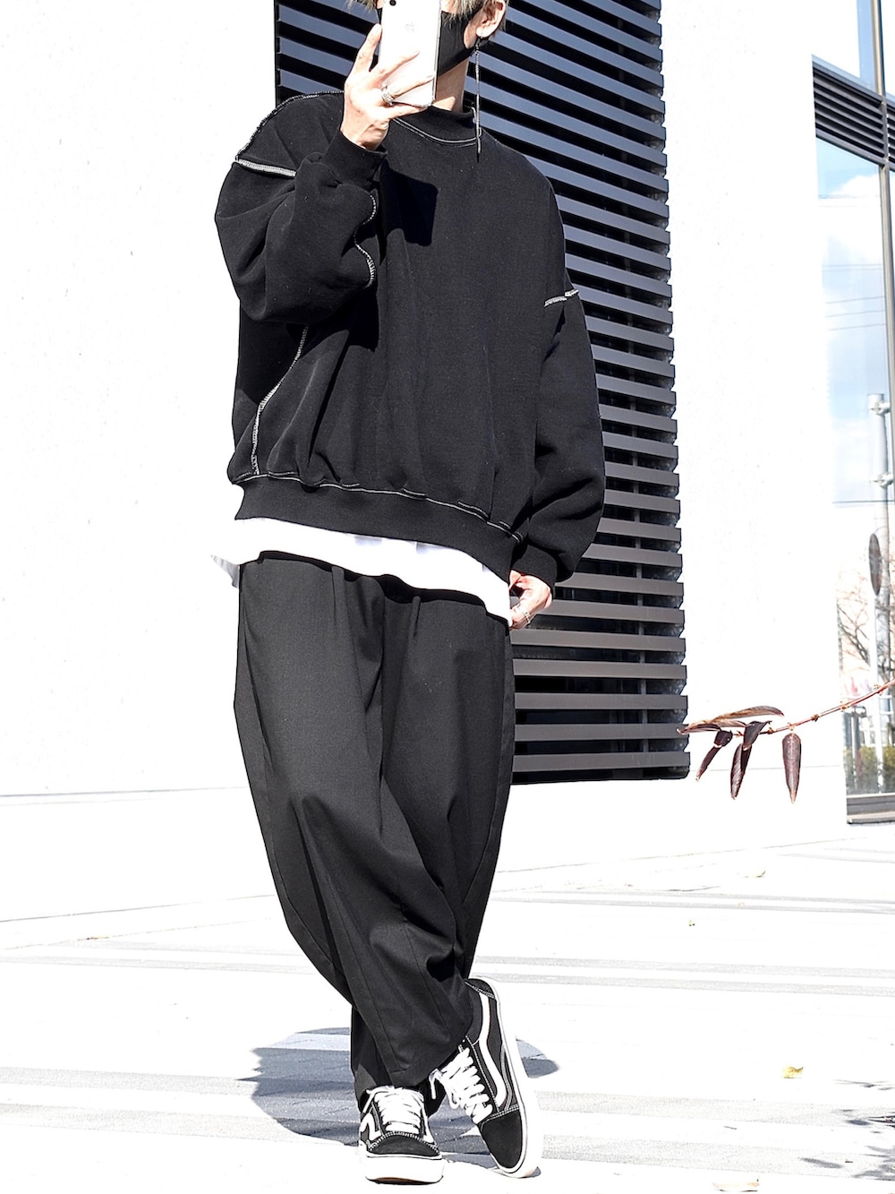 ブラック系のスウェット、ホワイト系のTシャツ/カットソー、ブラック系のスラックスを着用したメンズの冬コーディネートの2枚目の写真