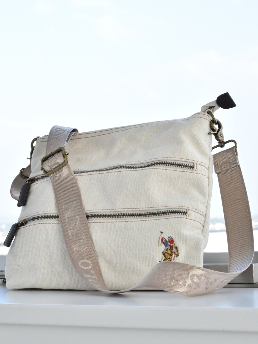 ホワイト系のショルダーバッグ、グレー系のベスト、ベージュ系のTシャツ/カットソーを着用したメンズの春コーディネートの3枚目の写真