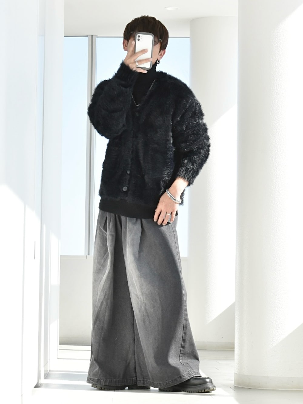 ブラック系のカーディガン/ボレロ、ブラック系のデニムパンツ、ブラック系のニット/セーターを着用したメンズの春コーディネートの3枚目の写真