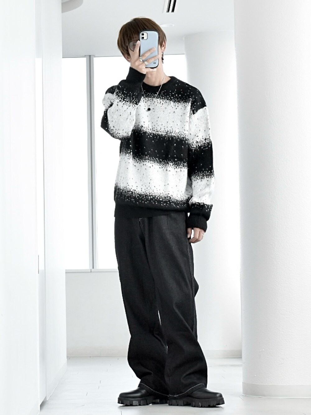 ブラック系のニット/セーター、ブラック系のダウンベスト、ブラック系のデニムパンツを着用したメンズの秋コーディネートの3枚目の写真