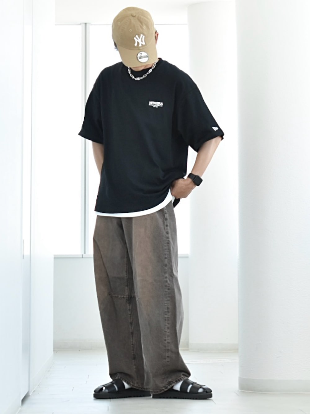 ブラック系のTシャツ/カットソー、ホワイト系のタンクトップ、ブラウン系のデニムパンツを着用したメンズの夏コーディネートの2枚目の写真