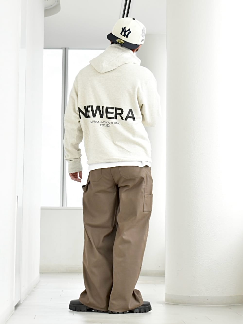 ブラック系のブーツ、ホワイト系のパーカー、ベージュ系のパンツを着用したメンズの秋コーディネートの3枚目の写真