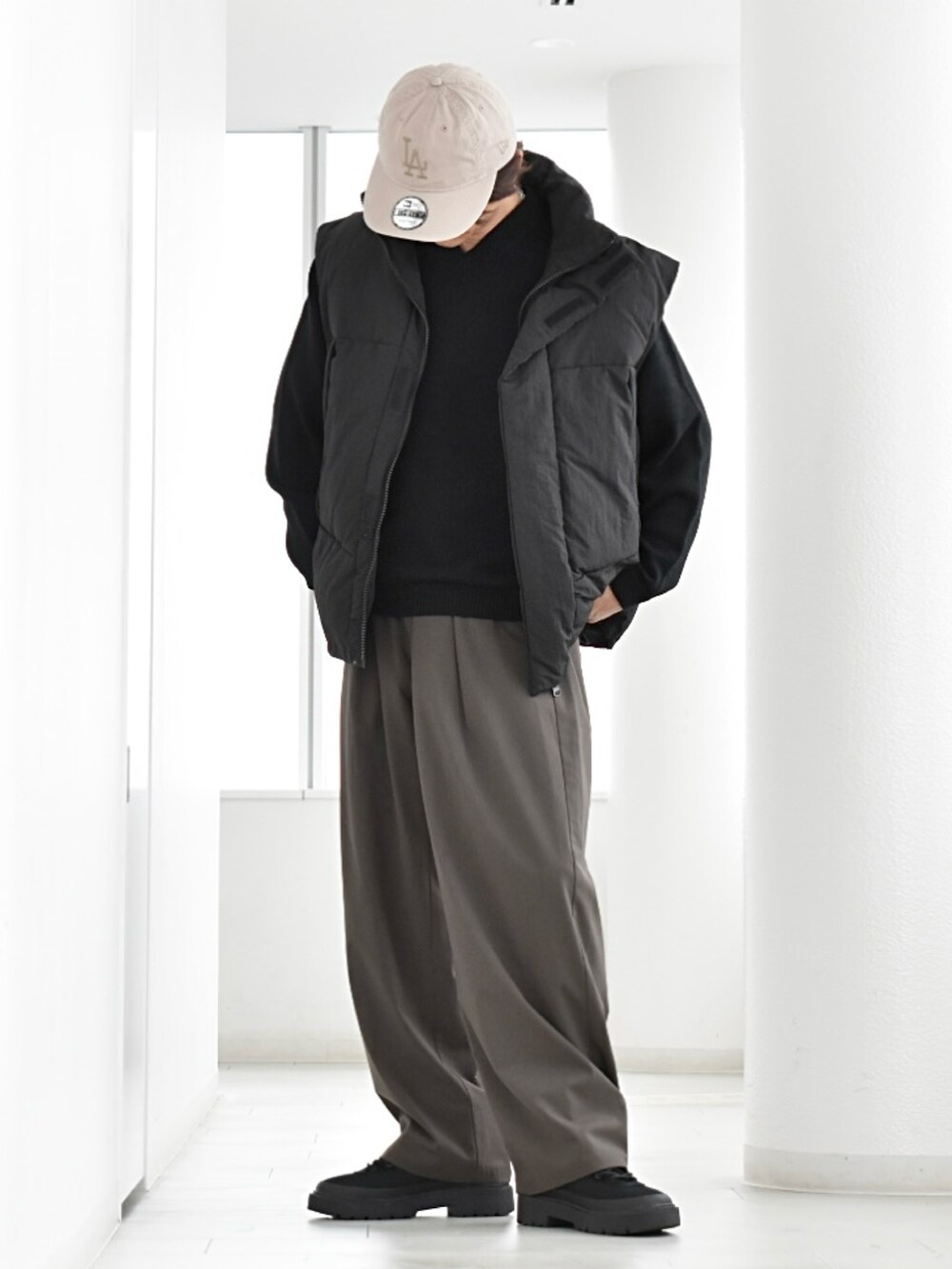 ブラック系のダウンベスト、その他のスラックス、ブラック系のブーツを着用したメンズの秋コーディネートの2枚目の写真