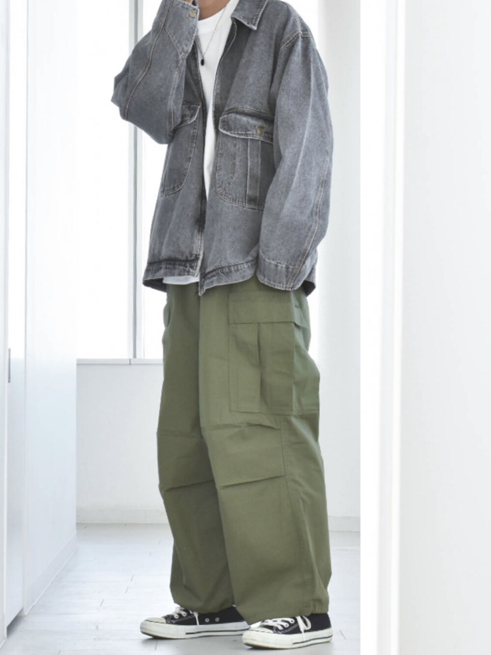 ブラック系のブルゾン、グリーン系のカーゴパンツ、ブラック系のスニーカーを着用したメンズの冬コーディネートの2枚目の写真