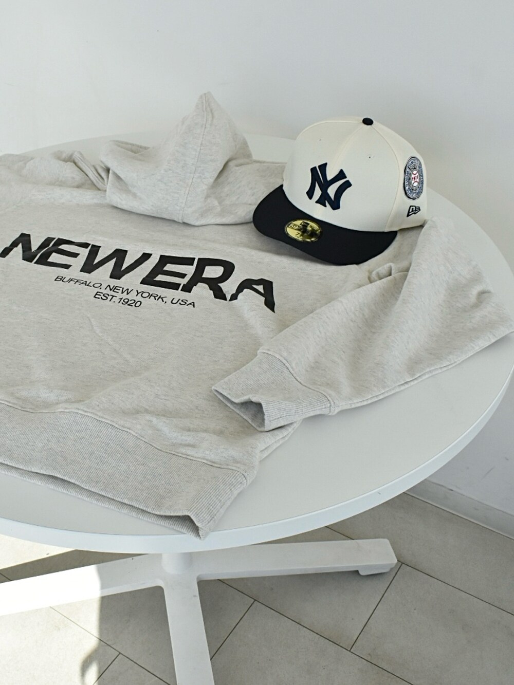 ブラック系のデニムパンツ、ホワイト系のパーカー、ブラック系のスニーカーを着用したメンズの冬コーディネートの5枚目の写真