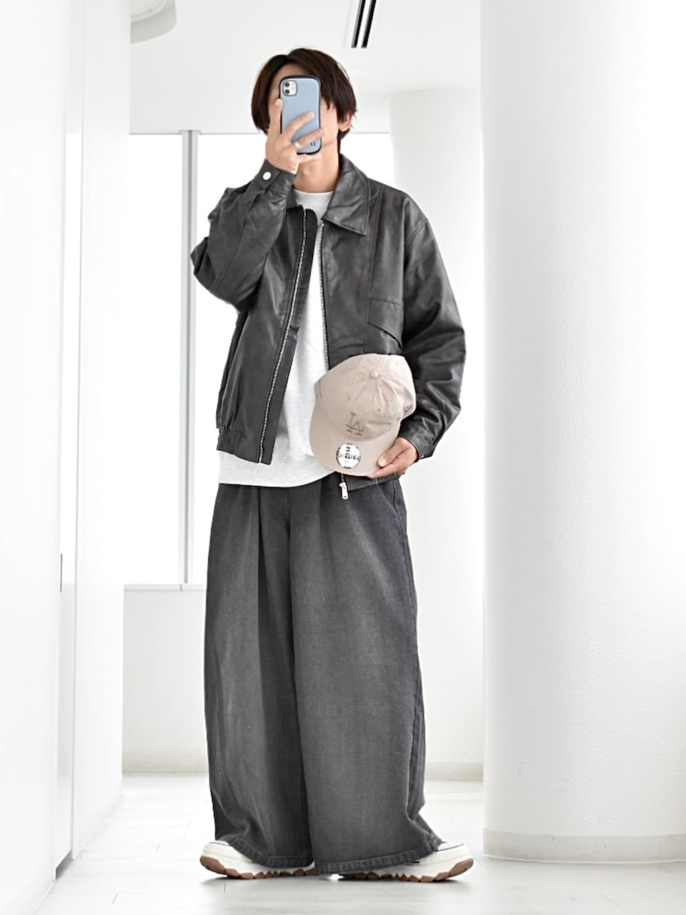 ブラック系のブルゾン、グレー系のスウェット、ブラック系のデニムパンツを着用したメンズの秋コーディネートの2枚目の写真