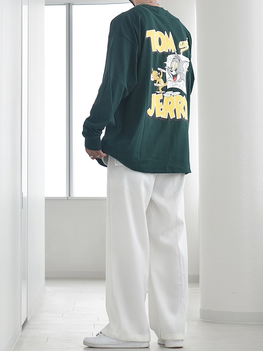 グリーン系のTシャツ/カットソー、ホワイト系のタンクトップ、ホワイト系のスラックスを着用したメンズの秋コーディネートの2枚目の写真
