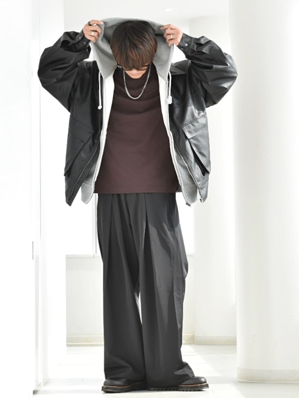 ブラック系のブルゾン、ブラック系のスラックス、グレー系のスウェットを着用したメンズの春コーディネートの3枚目の写真