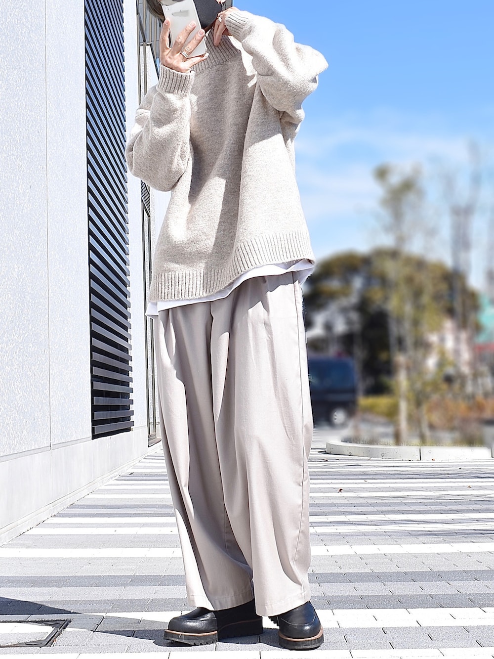 ベージュ系のニット/セーター、ホワイト系のTシャツ/カットソー、ベージュ系のスラックスを着用したメンズの冬コーディネートの2枚目の写真