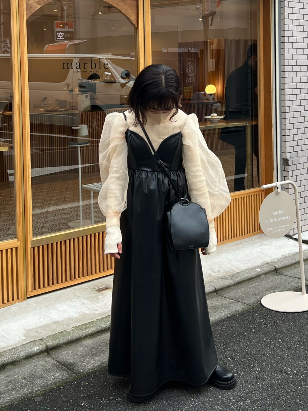 ブラック系のワンピース/ドレス、ブラック系のショルダーバッグ、ブラック系のブーツを着用したレディースの冬コーディネートの5枚目の写真