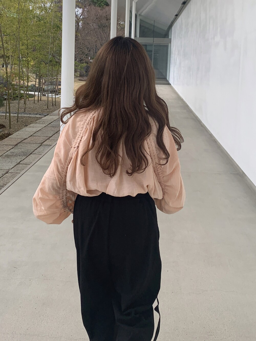 ブラック系のハンドバッグ、ブラック系のパンツ、ブラック系のローファーを着用したレディースの春コーディネートの4枚目の写真