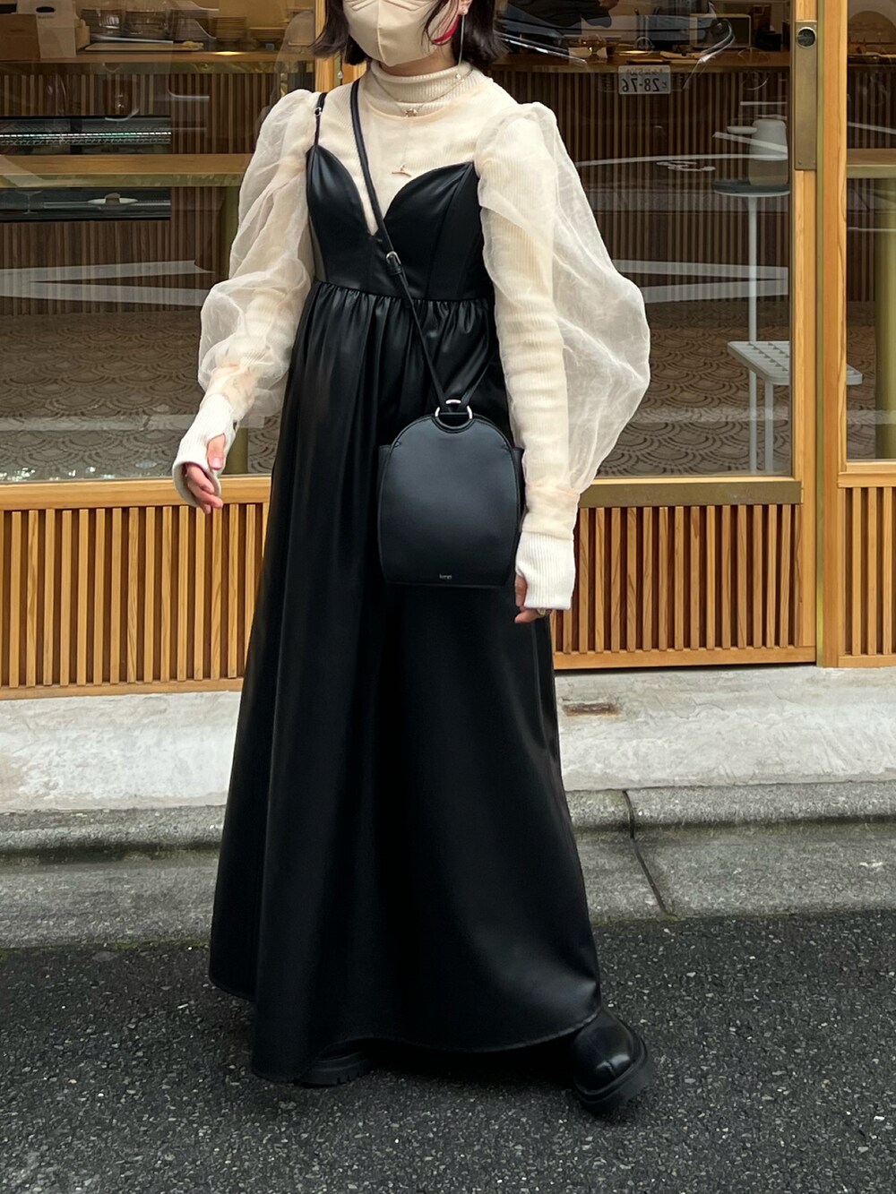 ブラック系のワンピース/ドレス、ブラック系のショルダーバッグ、ブラック系のブーツを着用したレディースの冬コーディネートの4枚目の写真