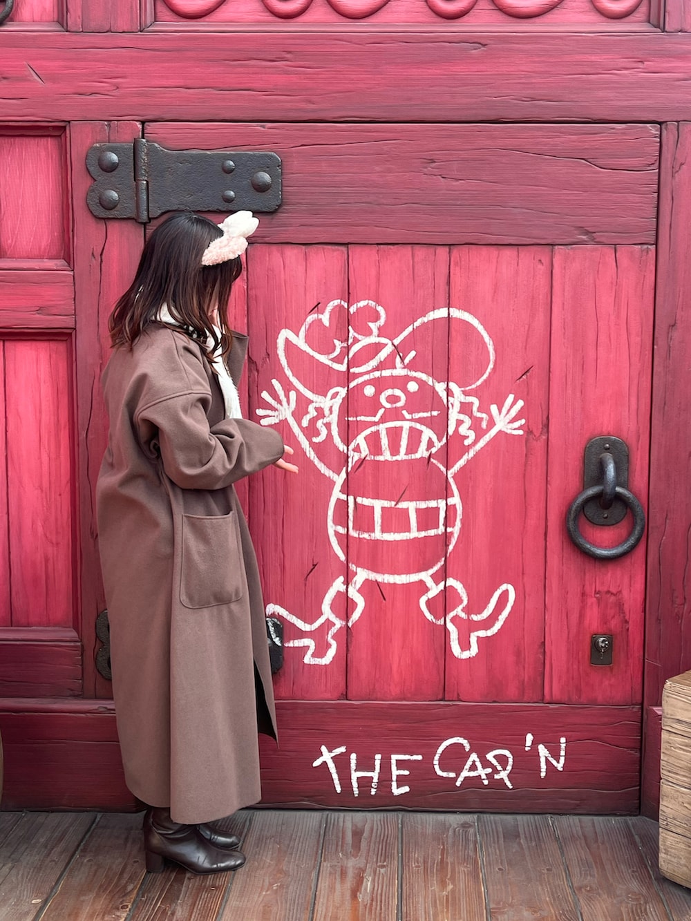 ブラウン系のダウンジャケット/コート、ベージュ系のトートバッグ、ベージュ系のニット/セーターを着用したレディースの冬コーディネートの2枚目の写真