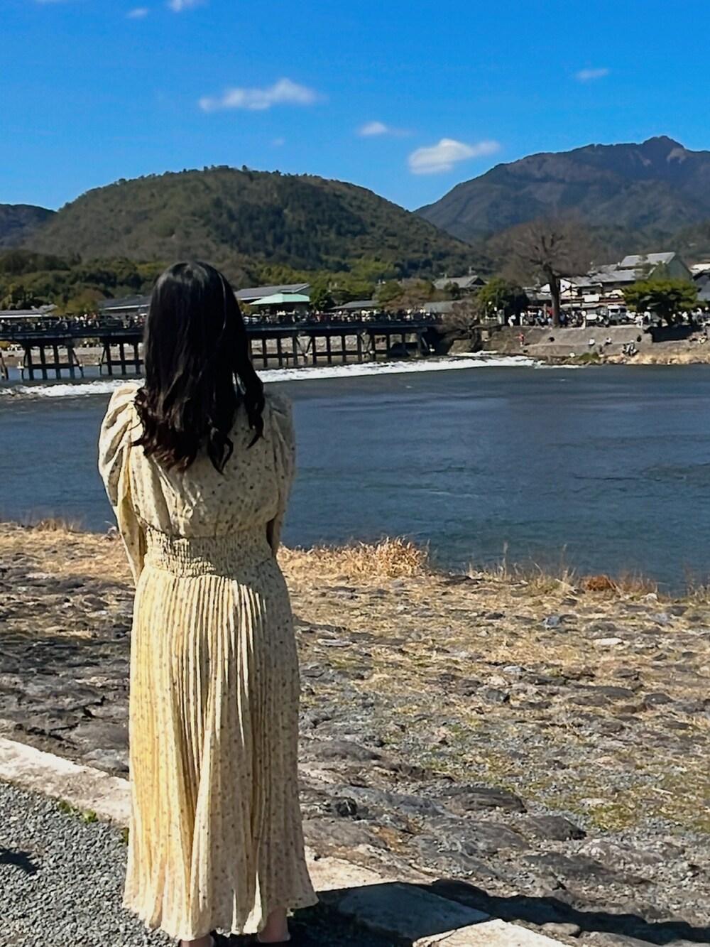 グレー系のジャケット/アウター、ベージュ系のショルダーバッグ、イエロー系のワンピースを着用したレディースの春コーディネートの2枚目の写真