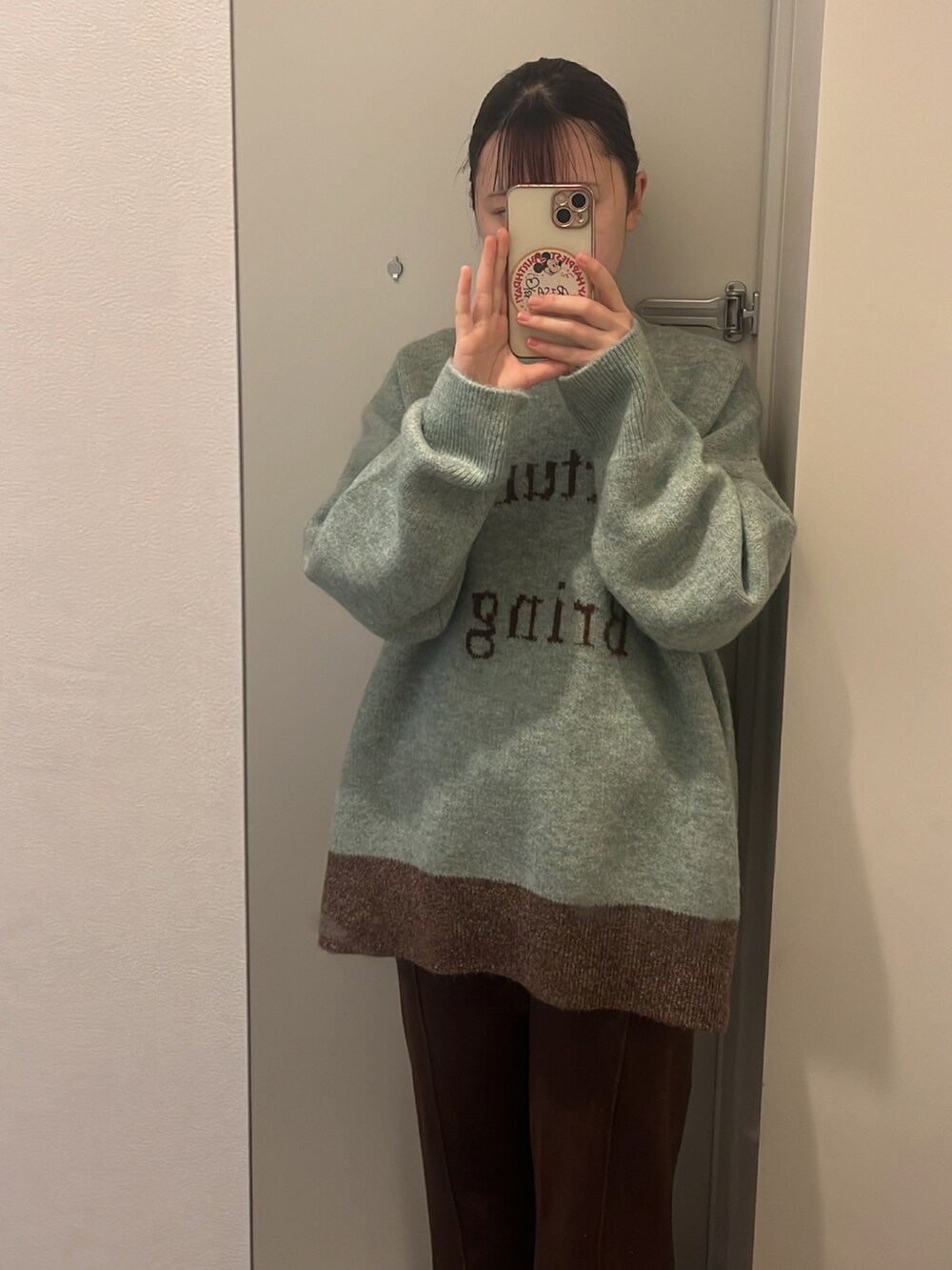 グリーン系のニット/セーター、ブラウン系のその他パンツ、ブラウン系のブーツを着用したレディースの冬コーディネートの2枚目の写真