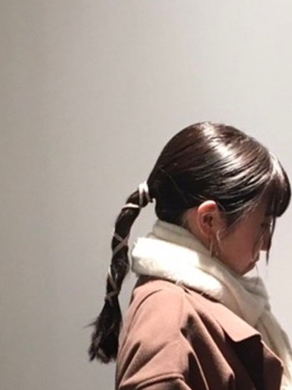 ブラック系のショルダーバッグ、ブラウン系のダウンジャケット/コート、ホワイト系のブーツを着用したレディースの冬コーディネートの2枚目の写真