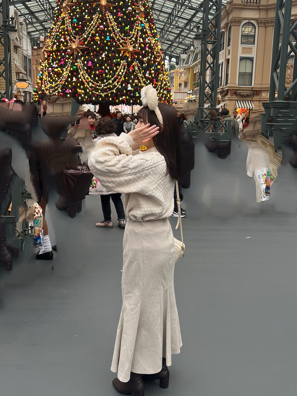 ホワイト系のショルダーバッグ、ホワイト系のスカート、ブラウン系のブーツを着用したレディースの冬コーディネートの2枚目の写真