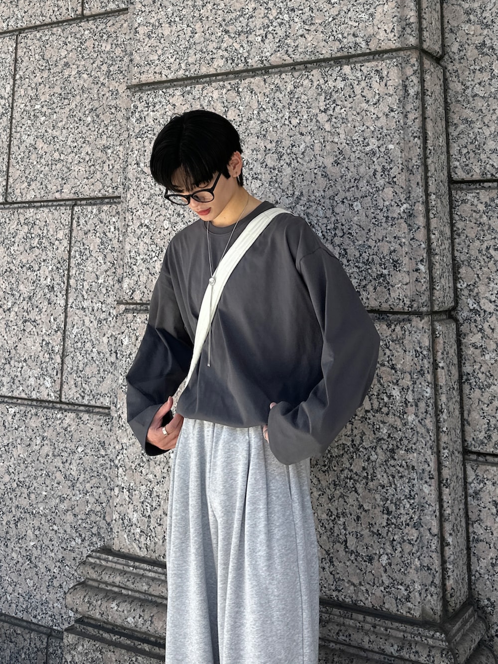 グレー系のTシャツ/カットソー、グレー系のスウェットパンツ、シルバー系のネックレスを着用したメンズの秋コーディネートの4枚目の写真