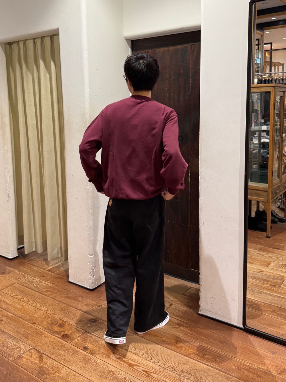 レッド系のスウェット、ブラック系のスニーカー、ブラック系のパンツを着用したメンズの秋コーディネートの3枚目の写真