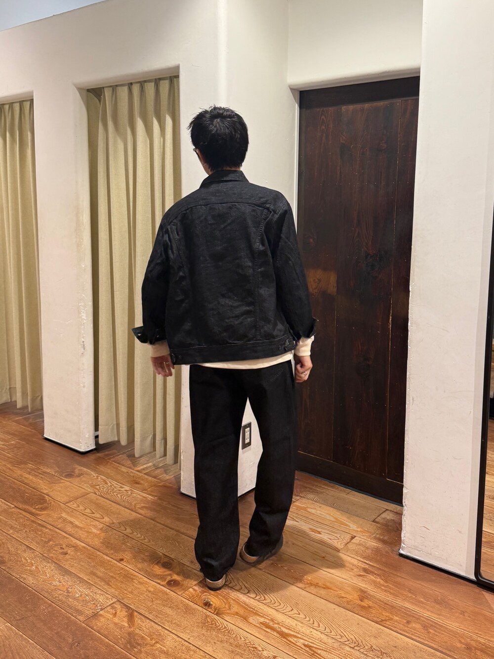 グレー系のサンダル、ブラック系のデニムパンツ、ブラック系のデニムジャケットを着用したメンズの夏コーディネートの2枚目の写真