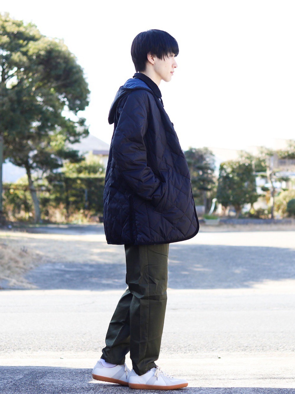 グレー系のニット/セーター、ブラック系のダウンジャケット/コート、グリーン系のパンツを着用したメンズの冬コーディネートの3枚目の写真