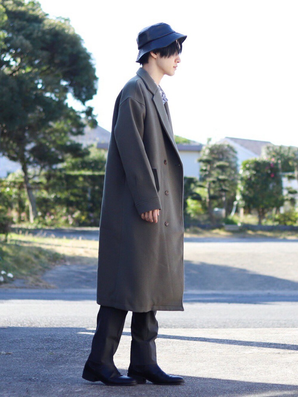 グレー系のチェスターコート、グレー系のシャツ/ブラウス、グレー系のスラックスを着用したメンズの秋コーディネートの2枚目の写真