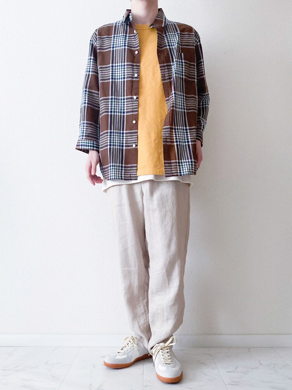 ブラウン系のシャツ/ブラウス、イエロー系のTシャツ/カットソー、ベージュ系のその他パンツを着用したメンズの春コーディネートの2枚目の写真