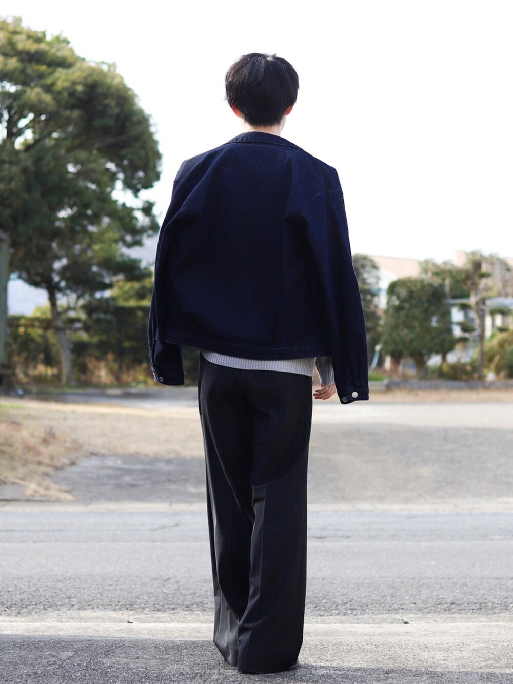 グレー系のニット/セーター、ブルー系のセットアップ、ブラック系のスラックスを着用したメンズの冬コーディネートの4枚目の写真