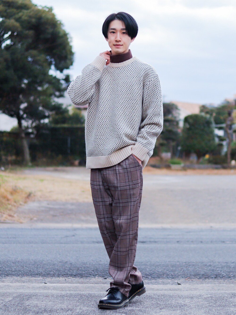 ホワイト系のニット/セーター、ブラック系のミリタリージャケット、ブラウン系のTシャツ/カットソーを着用したメンズの冬コーディネートの2枚目の写真