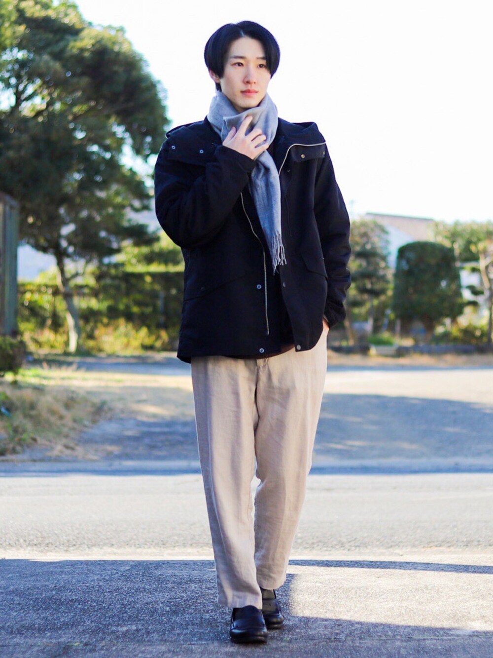 ブラック系のマウンテンパーカー、ブラウン系のTシャツ/カットソー、ベージュ系のその他パンツを着用したメンズの冬コーディネートの2枚目の写真