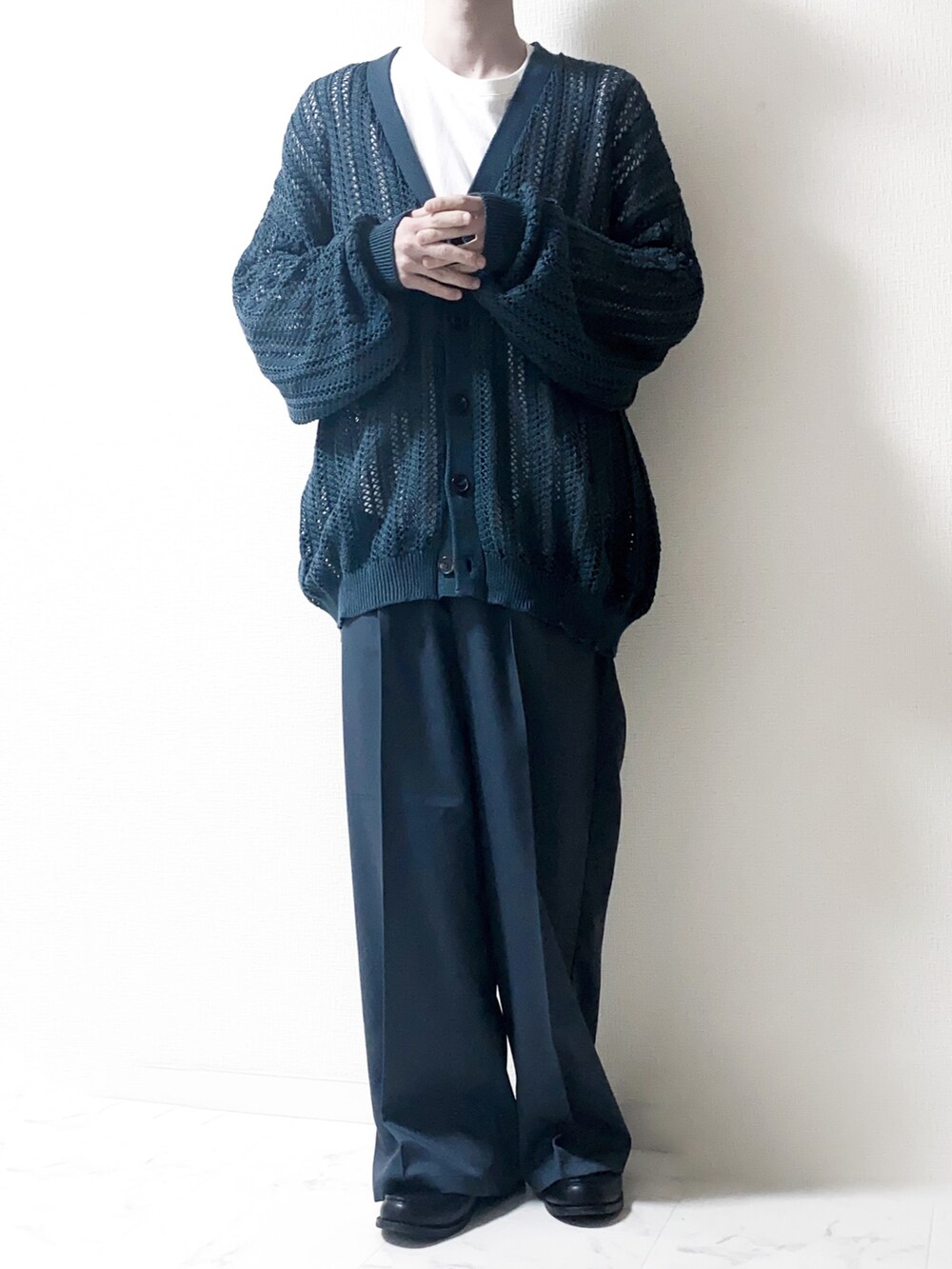 ブルー系のカーディガン/ボレロ、ベージュ系のニット/セーター、ブルー系のスラックスを着用したメンズの春コーディネートの2枚目の写真