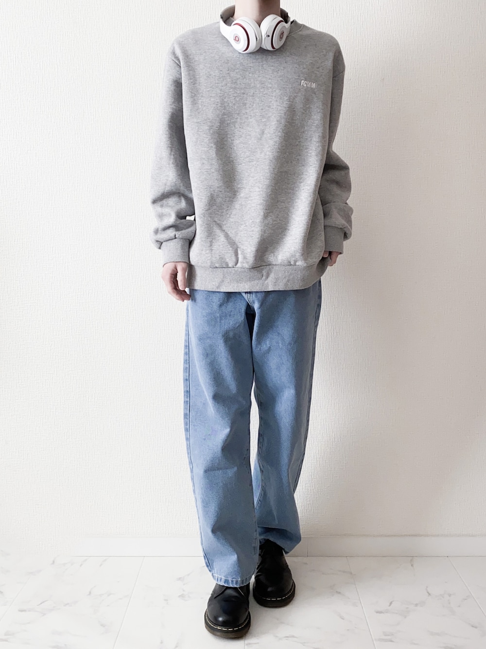 ブルー系のデニムパンツ、グレー系のスウェット、ブラック系のブーツを着用したメンズの春コーディネートの2枚目の写真