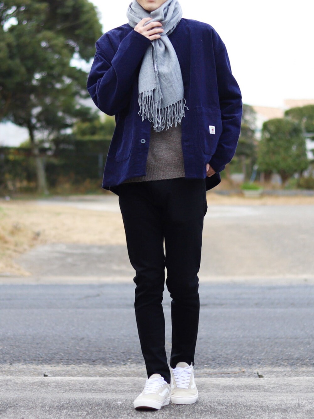 ブラック系のデニムパンツ、ブルー系のブルゾン、ベージュ系のニット/セーターを着用したメンズの冬コーディネートの2枚目の写真