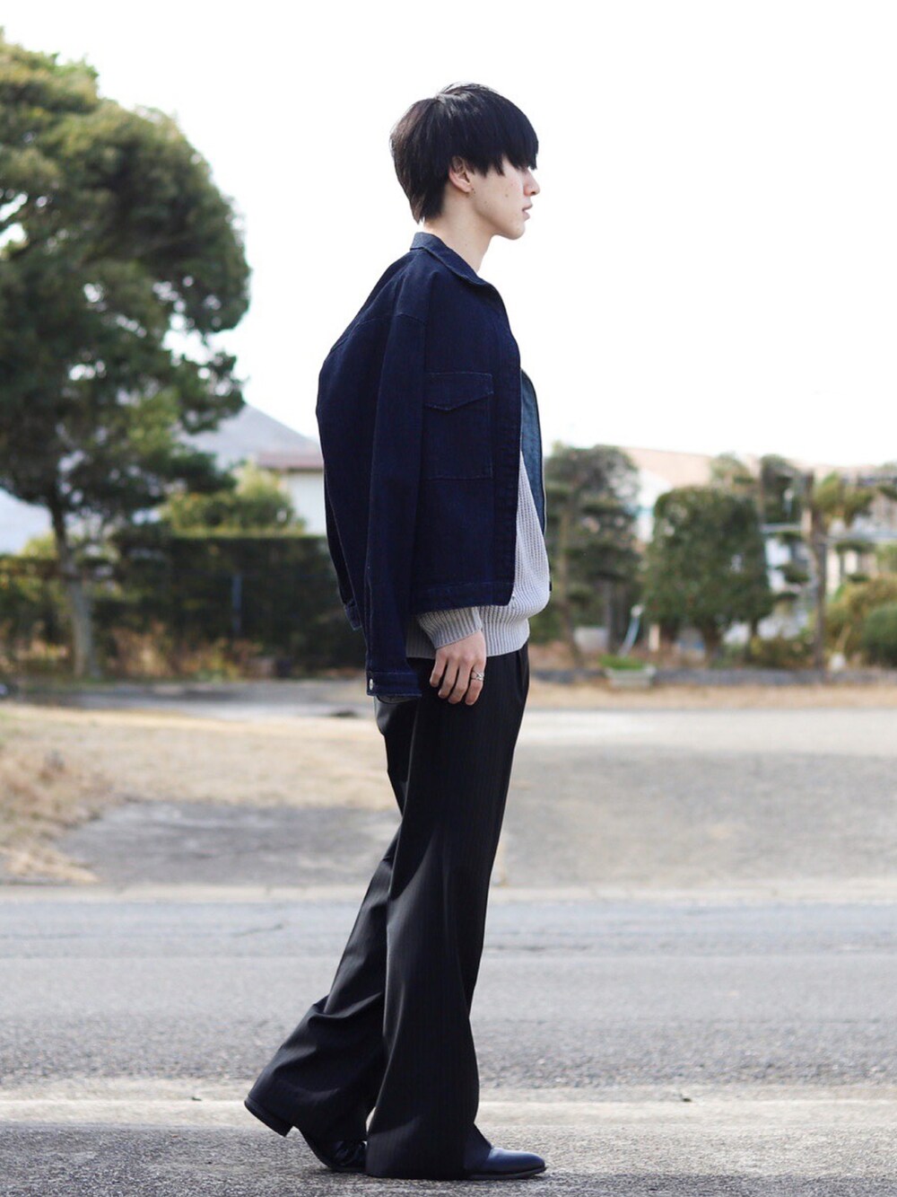 グレー系のニット/セーター、ブルー系のセットアップ、ブラック系のスラックスを着用したメンズの冬コーディネートの3枚目の写真