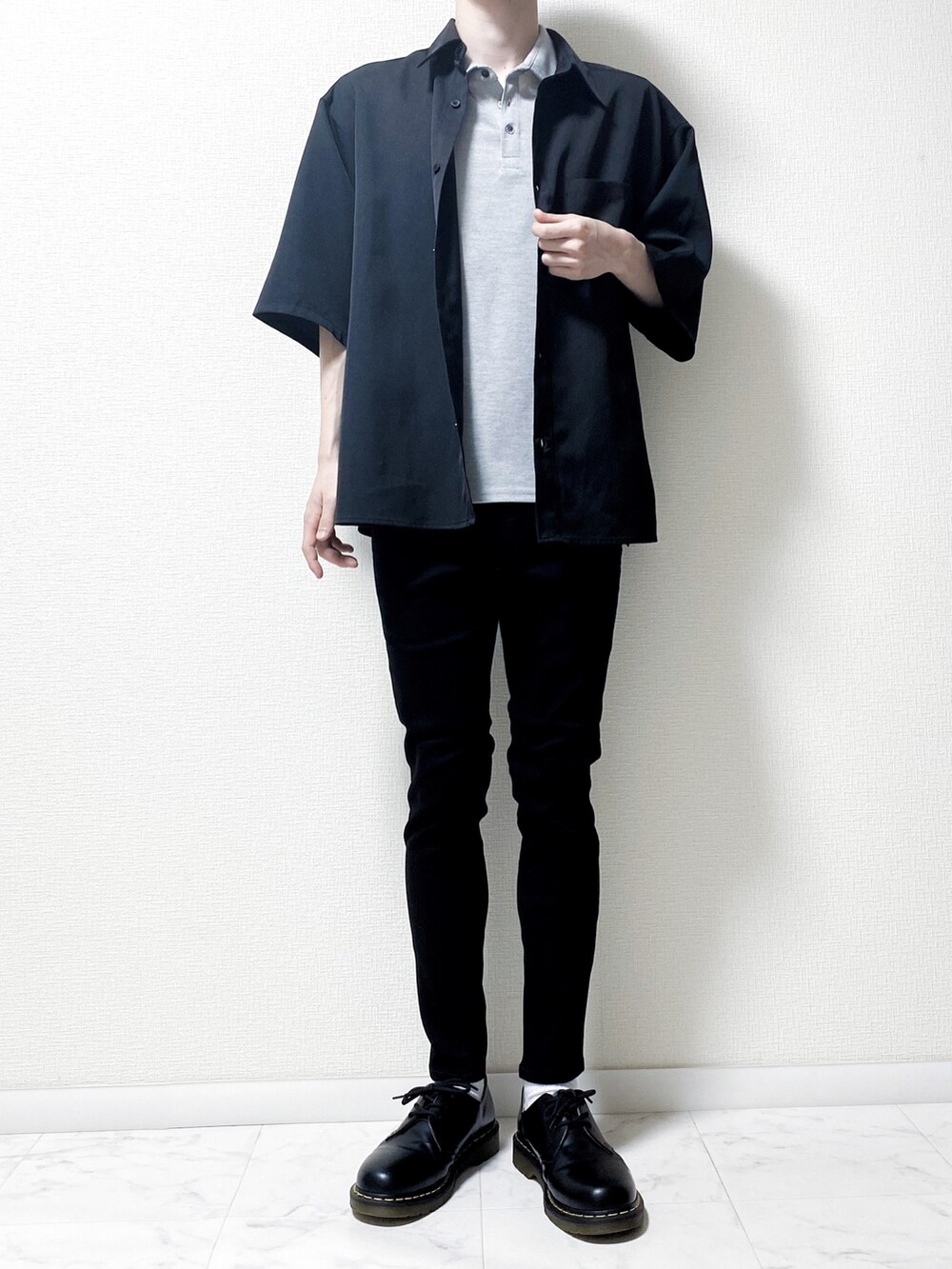 グレー系のポロシャツ、ブラック系のデニムパンツ、ブラック系のシャツ/ブラウスを着用したメンズの春コーディネートの2枚目の写真