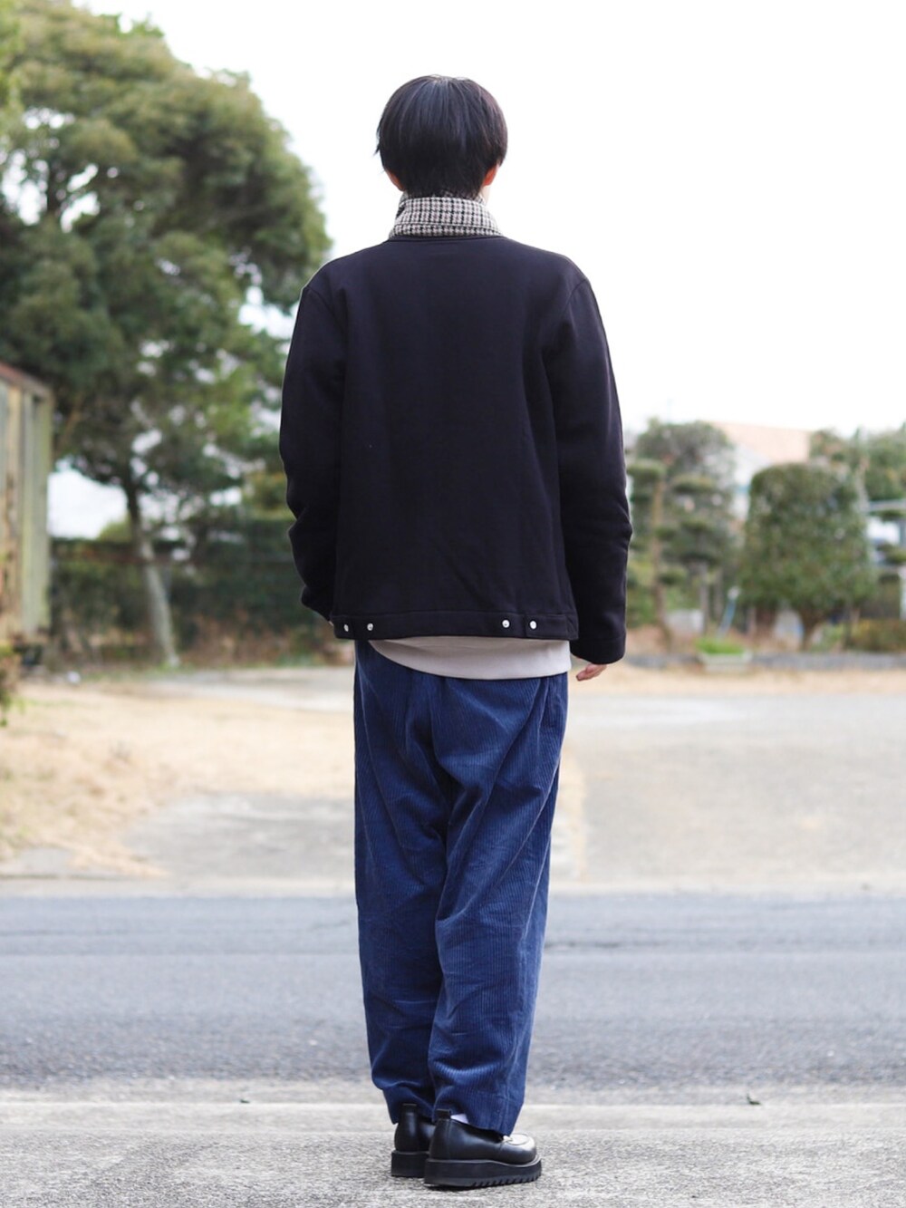 ブラック系のカーディガン/ボレロ、ベージュ系のスウェット、ブルー系のスラックスを着用したメンズの冬コーディネートの3枚目の写真