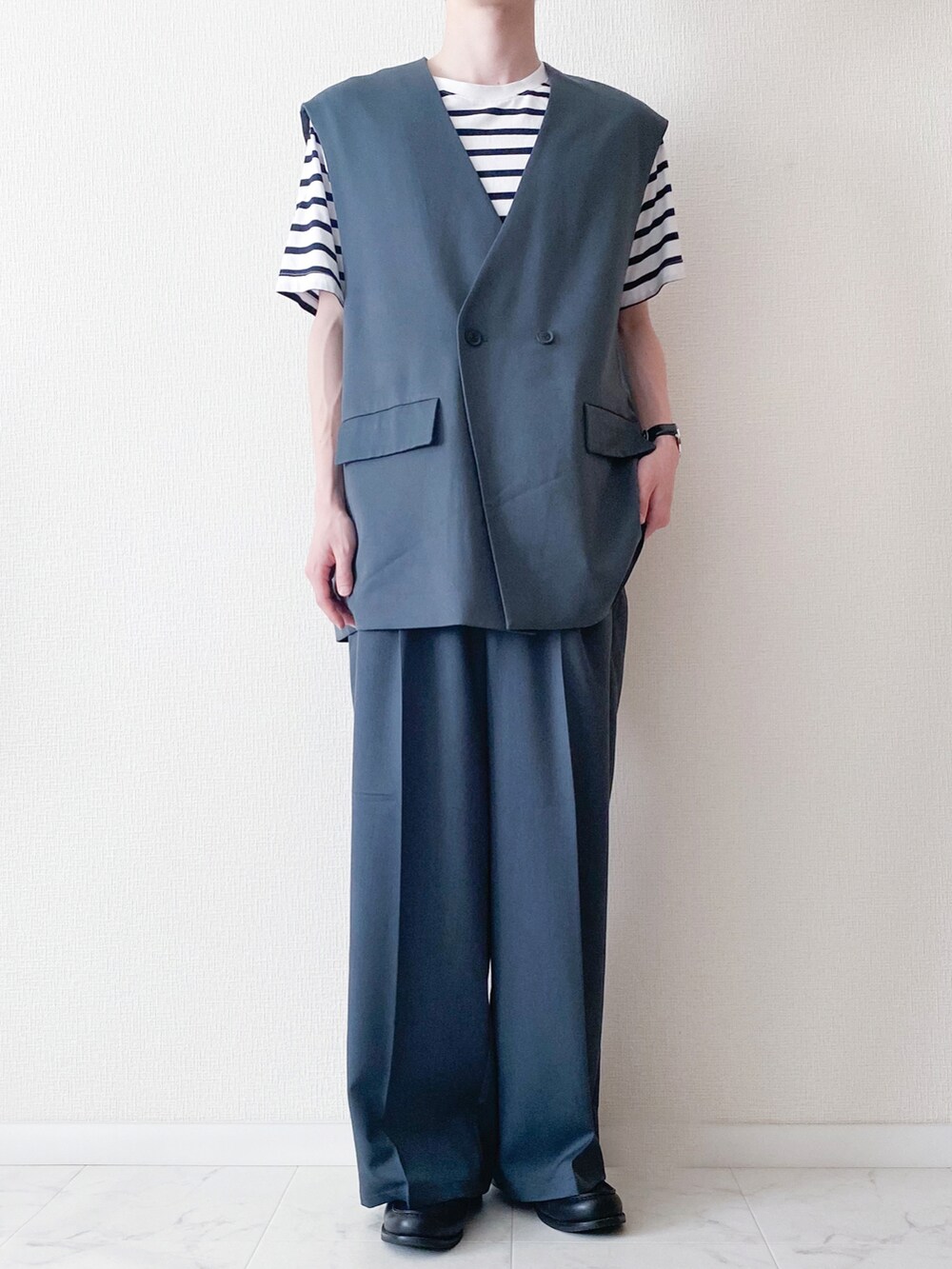 ブルー系のベスト、ブルー系のスラックス、ホワイト系のトップスを着用したメンズの夏コーディネートの2枚目の写真