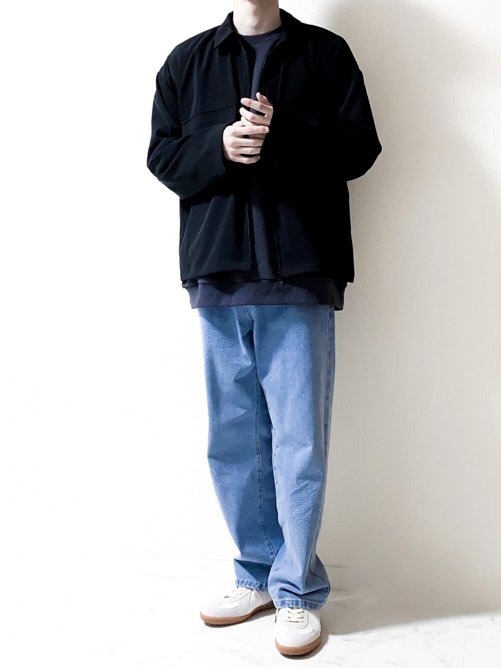 ブラック系のセットアップ、グレー系のスウェット、ブルー系のデニムパンツを着用したメンズの春コーディネートの2枚目の写真