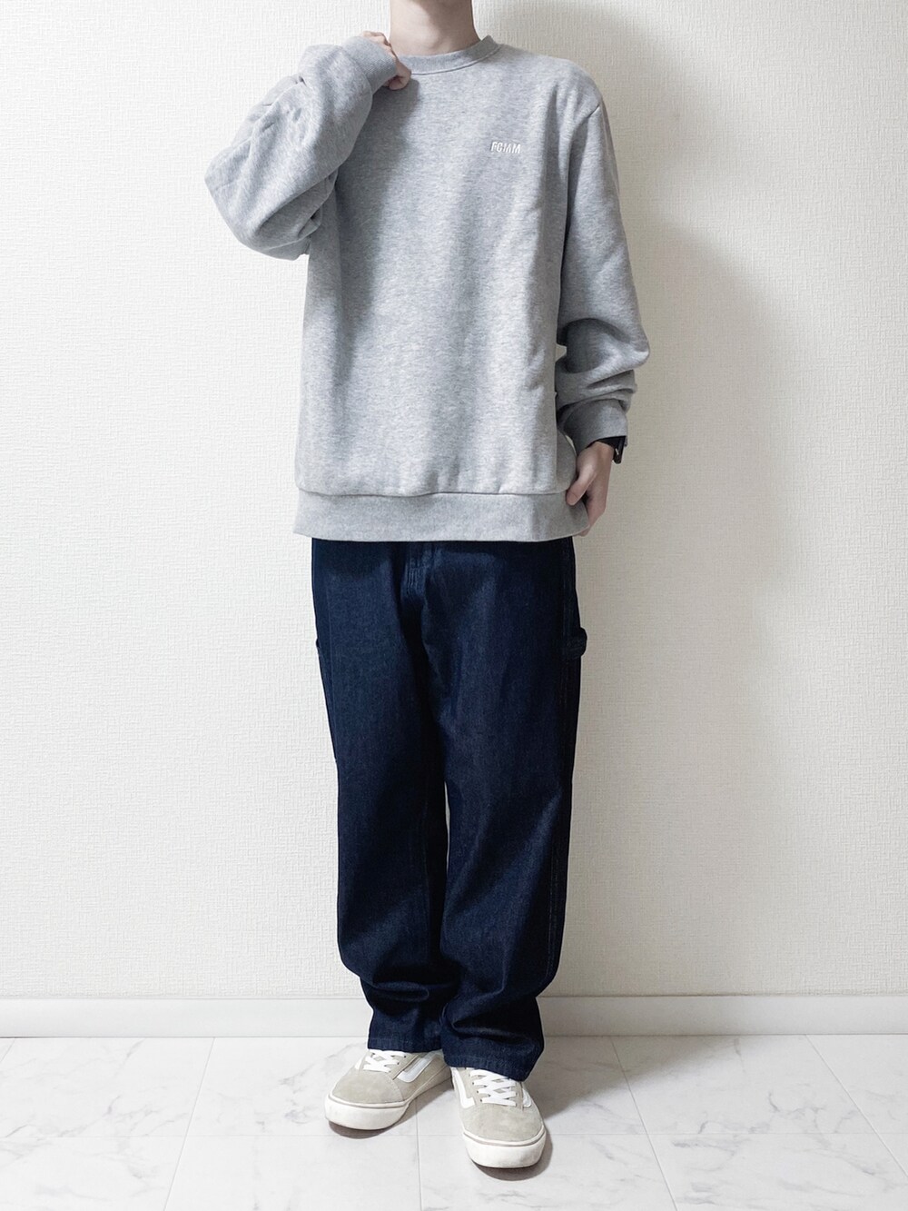 ブルー系のデニムパンツ、グレー系のスウェット、ベージュ系のスニーカーを着用したメンズの秋コーディネートの2枚目の写真