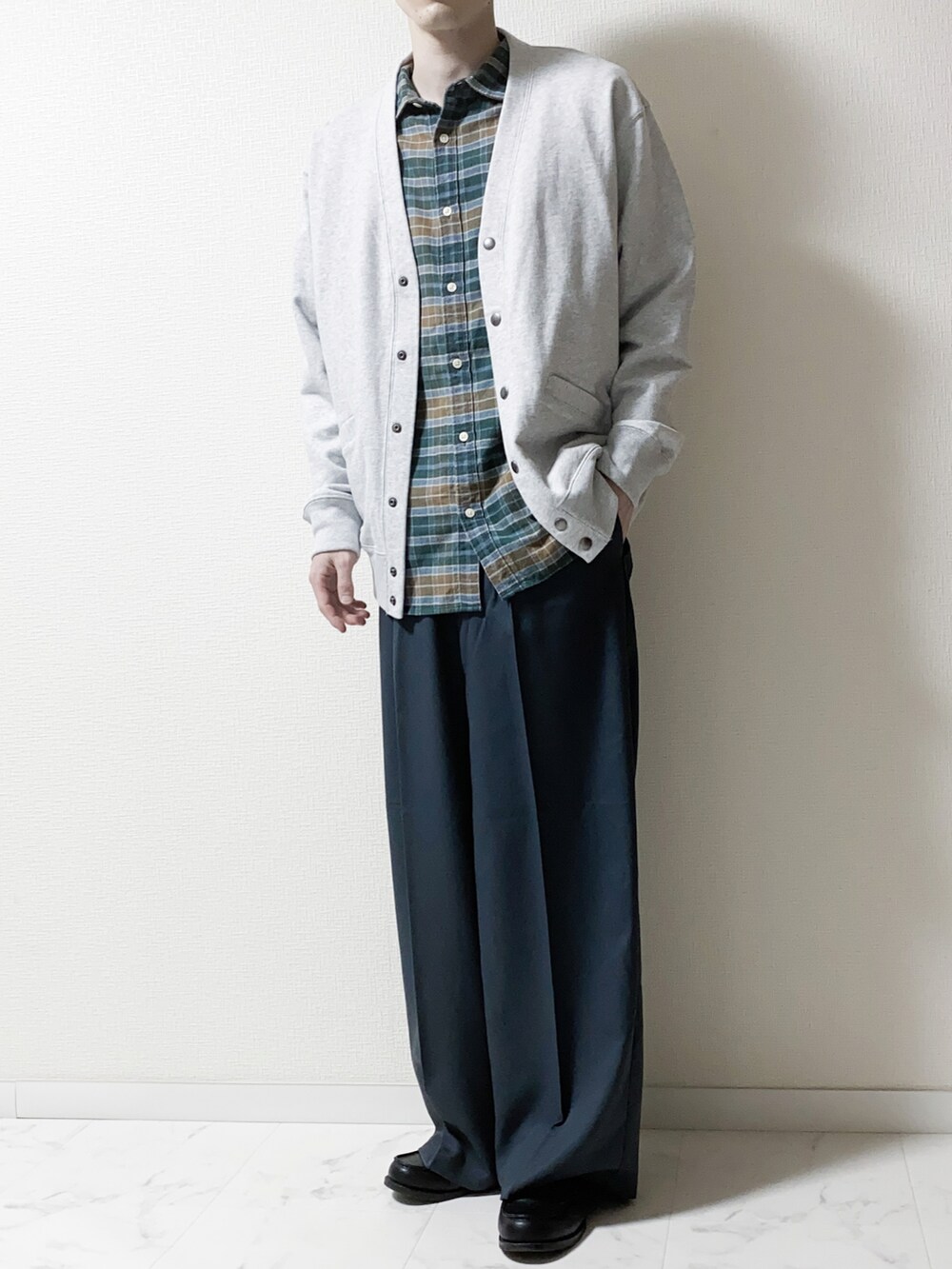 グレー系のカーディガン/ボレロ、グリーン系のシャツ/ブラウス、ブルー系のスラックスを着用したメンズの春コーディネートの2枚目の写真