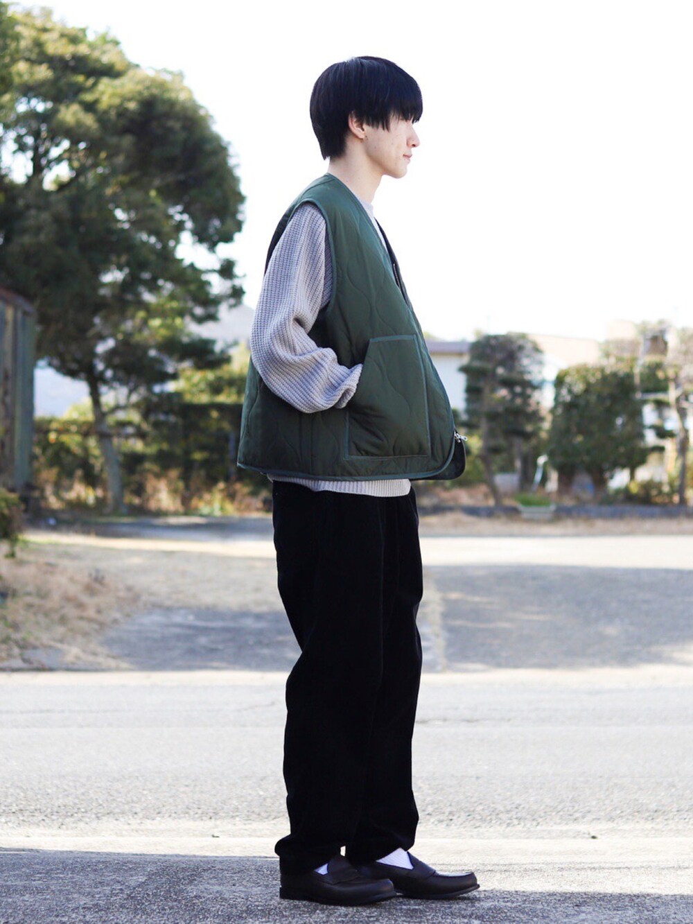 グレー系のニット/セーター、グリーン系のベスト、ブラック系のその他パンツを着用したメンズの冬コーディネートの3枚目の写真