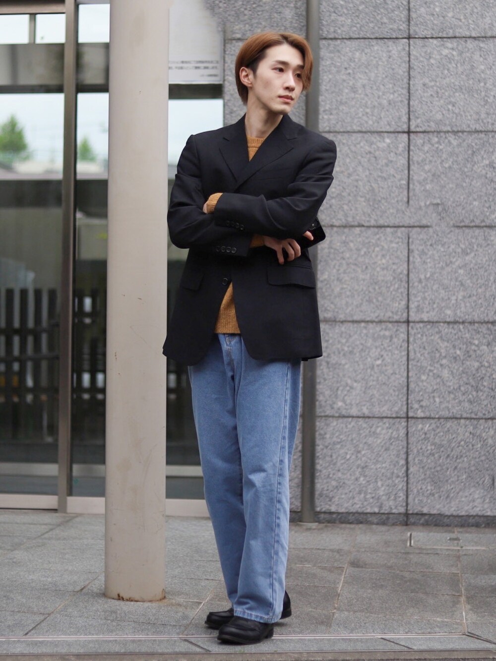 イエロー系のニット/セーター、ブルー系のデニムパンツ、ブラック系のローファーを着用したメンズの春コーディネートの2枚目の写真