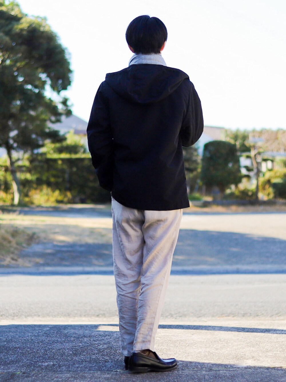 ブラック系のマウンテンパーカー、ブラウン系のTシャツ/カットソー、ベージュ系のその他パンツを着用したメンズの冬コーディネートの4枚目の写真