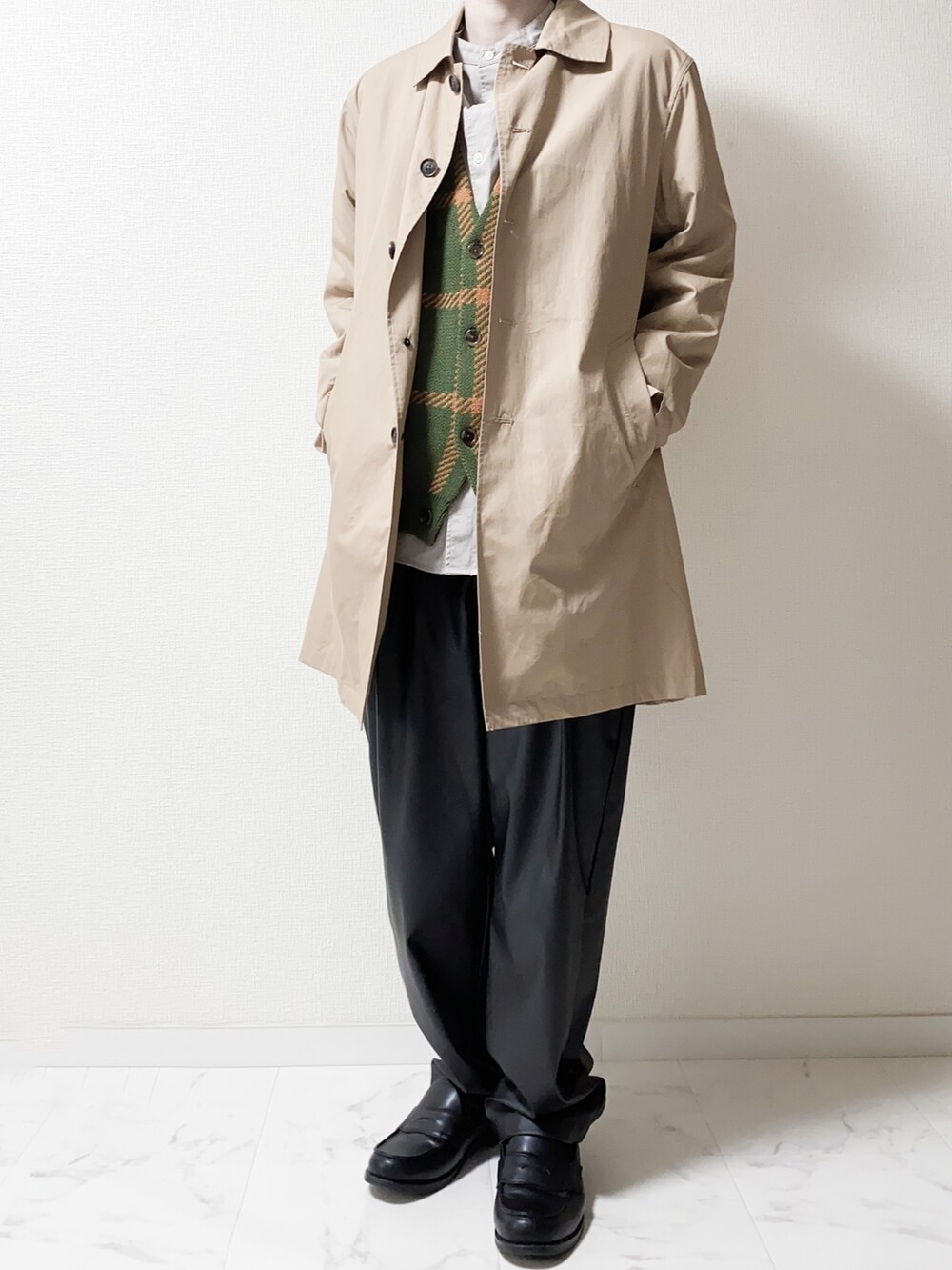 ベージュ系のステンカラーコート、グリーン系のカーディガン/ボレロ、ブラック系のその他パンツを着用したメンズの春コーディネートの2枚目の写真