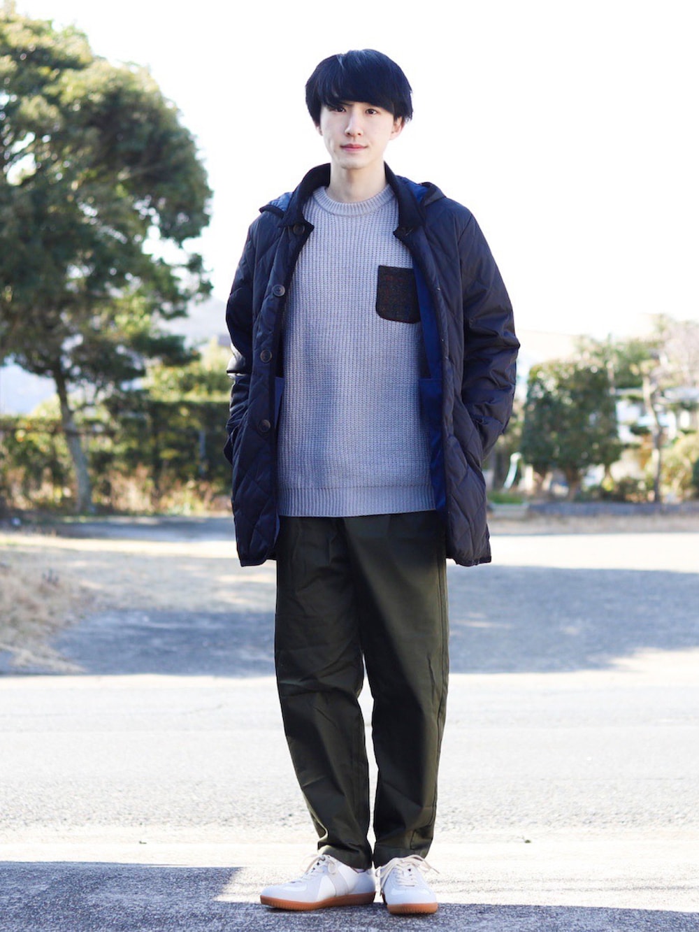 グレー系のニット/セーター、ブラック系のダウンジャケット/コート、グリーン系のパンツを着用したメンズの冬コーディネートの2枚目の写真