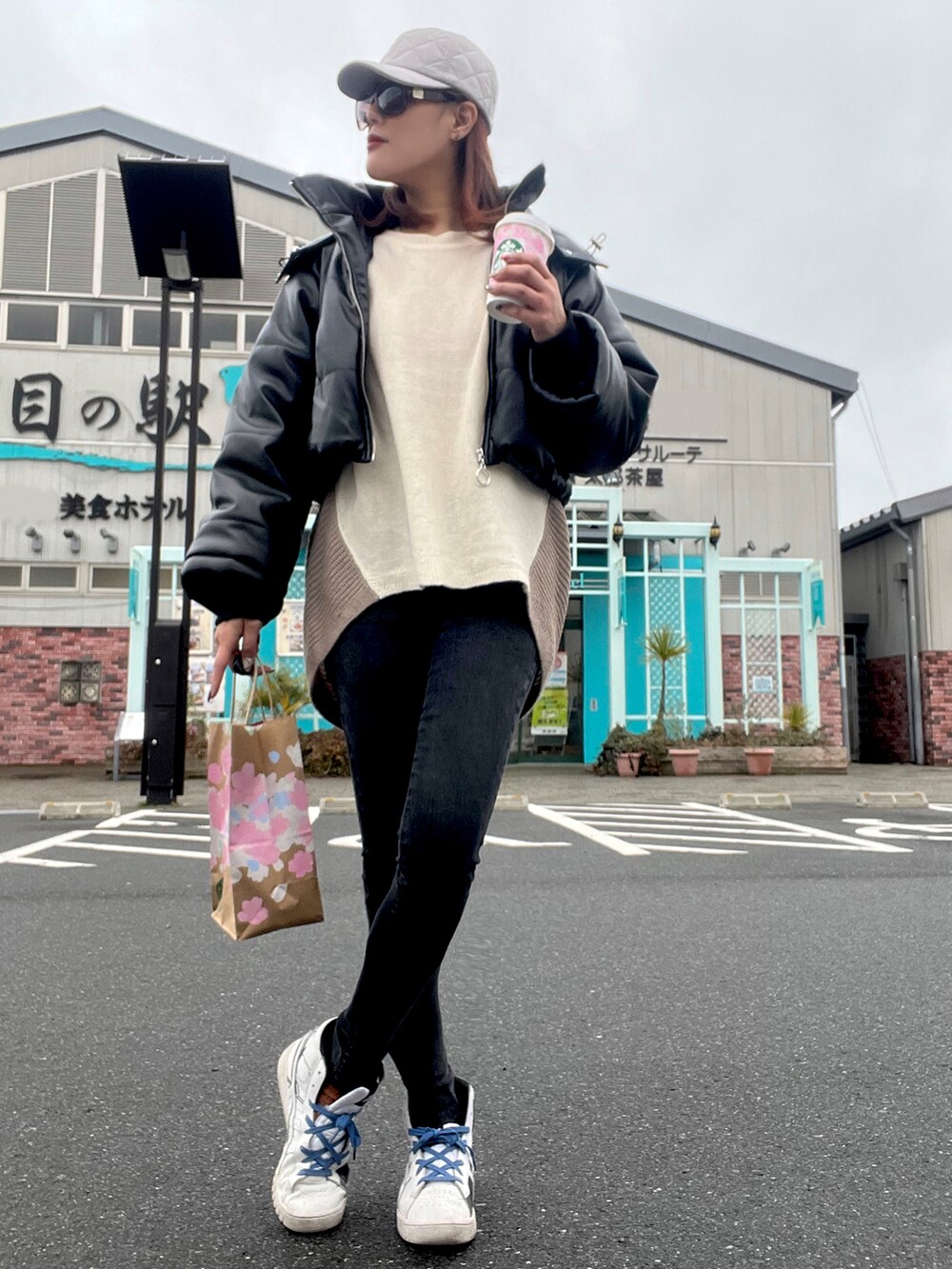 ホワイト系のスニーカー、グレー系のデニムパンツ、ベージュ系のニット/セーターを着用したレディースの冬コーディネートの2枚目の写真